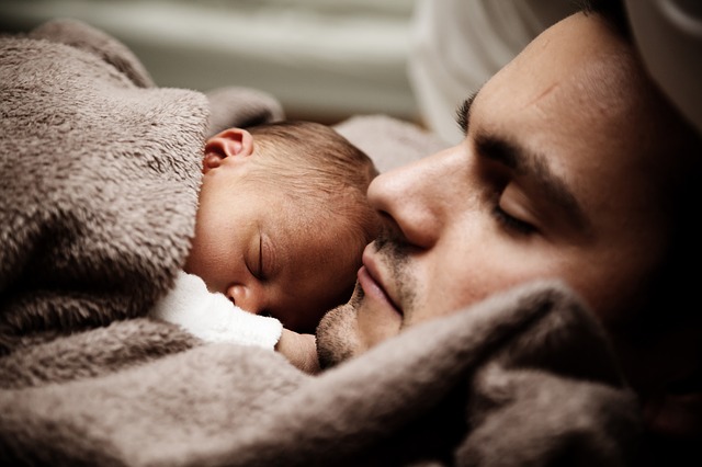 Homme dormant avec un bébé.
